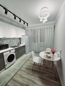 a kitchen with a table and chairs and a microwave at PERFECT APARTMENTS in Almaty