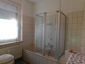 a bathroom with a shower and a bath tub at Ferienwohnung Adler in Auerbach