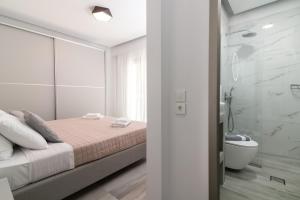 ein weißes Schlafzimmer mit einem Bett und einer Dusche in der Unterkunft Franko's House in Laganas