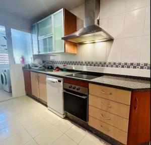 a kitchen with wooden cabinets and a stove top oven at Guests House River in Málaga
