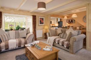 a living room with two couches and a table at Dryburgh Stirling Two in Saint Boswells