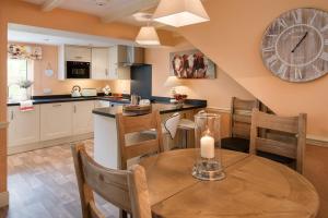 een keuken met een tafel en een klok aan de muur bij Dryburgh Stirling Two in Saint Boswells
