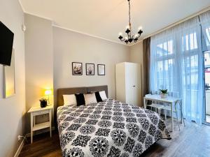 a bedroom with a bed with a black and white comforter at Studio przy Placu Jasia Rybaka in Sopot