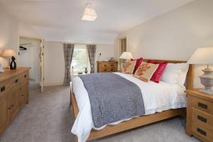 a bedroom with a large bed with red pillows at Dryburgh Stirling One in Saint Boswells