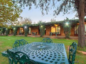 een tafel en stoelen voor een huis bij Airport Game Lodge in Kempton Park