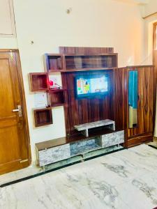 a living room with a tv and a wooden wall at Sunrise guesthoues in Greater Noida