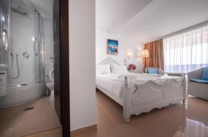 a bedroom with a white bed and a bathroom at SunRise in Venus +127 photos
