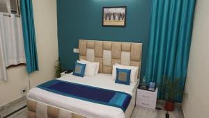 a bedroom with a bed with blue walls and blue curtains at Sunrise guesthoues in Greater Noida