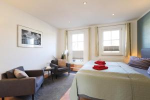 - une chambre avec un lit, une chaise et deux fenêtres dans l'établissement Appartementhaus Strandnähe, à Warnemünde
