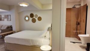 a bedroom with a bed and a bathroom with a shower at Euphoria Apartments Monastiraki in Athens +63 photos