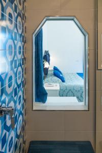 einen Spiegel im Bad mit einem Bett im Zimmer in der Unterkunft Florida Residence in Positano