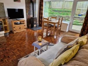 a living room with a couch and a table at Rosemary Cottage, Uley, Gloucestershire in Uley