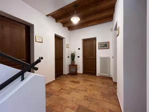 a hallway with white walls and wooden floors and doors at Locanda Corte Ruspecchio in Quattro Castella