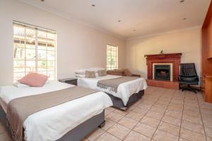a bedroom with two beds and a fireplace at Riverdance in Komnader