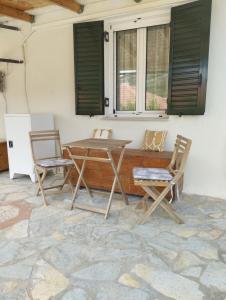 a patio with a table and chairs and windows at Atsoupi Home in Ratzaklíon +13 photos