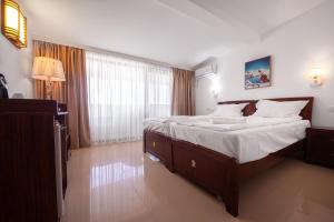 a bedroom with a large bed with white sheets at SunRise in Venus