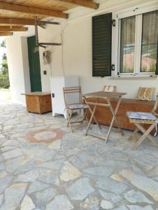 a patio with a table and chairs on a stone floor at Atsoupi Home in Ratzaklíon