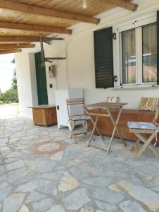 een patio met een tafel en stoelen op een stenen vloer bij Atsoupi Home in Ratzaklíon