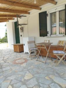 a patio with a table and chairs on a stone floor at Atsoupi Home in Ratzaklíon