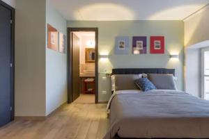 a bedroom with a large bed and a hallway at Relais al Porto Suite ORA in Peschiera del Garda