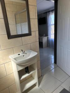 a bathroom with a white sink and a mirror at Maphuthi River Lodge in Ga-Manapane