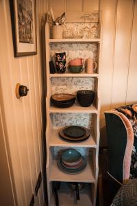 a shelf with plates and bowls in a room at The Garden Hut Cilcain in Mold