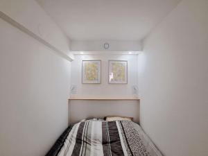a small bedroom with a bed in a white room at Riga, Appartement Hyper-centre in Reims