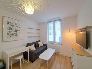 a living room with a couch and a table at Riga, Appartement Hyper-centre in Reims