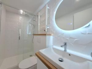 a white bathroom with a sink and a mirror at Riga, Appartement Hyper-centre in Reims