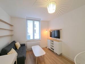 a living room with a couch and a tv at Riga, Appartement Hyper-centre in Reims