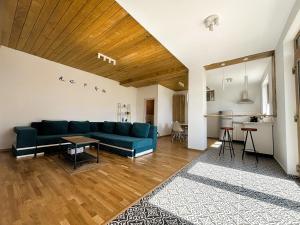 a living room with a blue couch and a kitchen at Casa Aluna Duo in Bran +99 photos
