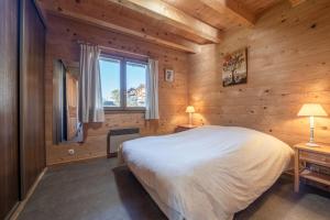 um quarto com uma cama grande e uma janela em Chambres d'hôtes Contamines-Monjoie Tour du Mont-Blanc em Les Contamines-Montjoie