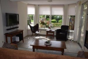 sala de estar con sofá y TV en Ruim vakantiehuis, rustig gelegen in Bruinisse, en Bruinisse