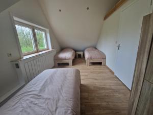 1 dormitorio con 2 sillas, 1 cama y 1 ventana en Ruim vakantiehuis, rustig gelegen in Bruinisse, en Bruinisse