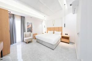 1 dormitorio blanco con 1 cama y 1 silla en شاليهات شاطىء غروب الشمس لبيوت العطلات en Jazán