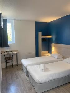 una habitación de hotel con 2 camas y una silla en Kyriad Direct Dreux en Dreux
