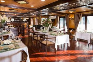 a dining room with white tables and chairs at Hera Cruises Group on Ha Long Bay in Ha Long