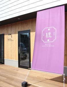 einem lila Vorhang vor einem Gebäude in der Unterkunft Matoi Hostel & Bar in Takasaki