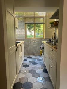 une cuisine avec des armoires blanches et un sol carrelé dans l'établissement Casa Beluga, à Pisciotta