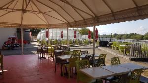 un restaurante al aire libre con mesas, sillas y sombrilla en Mobil-home 3ch, 2 sdbwc, tout confort camping les allais Trogues, en Trogues