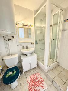 ein Bad mit einem Waschbecken, einem WC und einer Dusche in der Unterkunft Joli appartement cosy – Terrasse face à la mer in Ploemeur