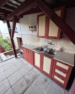 a kitchen with red and white cabinets and a sink at Diókert Vendégház in Komjáti