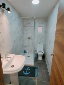een badkamer met een wastafel, een douche en een toilet bij Piso Gandia in Gandía