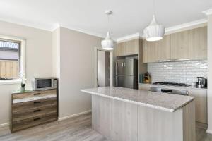 cocina con encimera y nevera en Brand new House close to shops in Dunes estate en Torquay