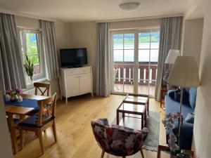 a living room with a table and chairs and a television at Wallner am See in St. Wolfgang