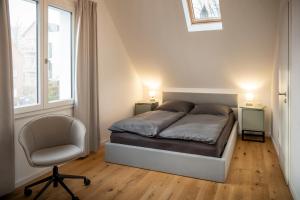 a bedroom with a bed and a chair and a window at Burgstübchen - Apartments - Innenstadt - hochwertig in Nordhorn