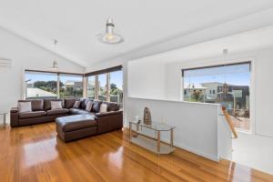 a living room with a couch and a table at Half Moon Bay Hideaway 1 min to Foreshore in Indented Head