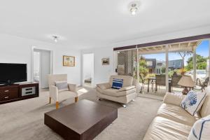 a living room with a couch and chairs and a tv at Half Moon Bay Hideaway 1 min to Foreshore in Indented Head