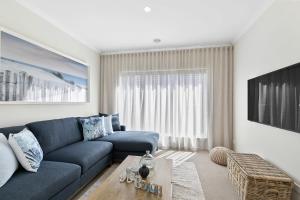 a living room with a blue couch and a table at Hampton's Getaway in Torquay in Torquay