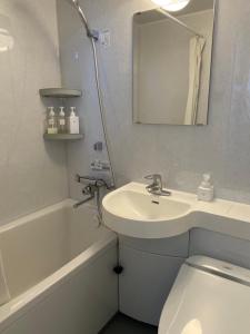 a bathroom with a sink and a toilet and a mirror at Matoi Hostel & Bar in Takasaki +17 photos